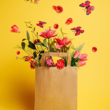 Paper,Bag,With,Fresh,Flowers,And,Butterflies,Flying,Against,Vibrant